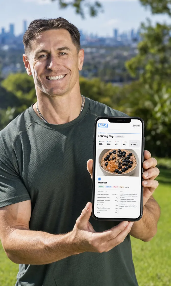 Mitch, MLA founder, holding a client meal plan on his phone